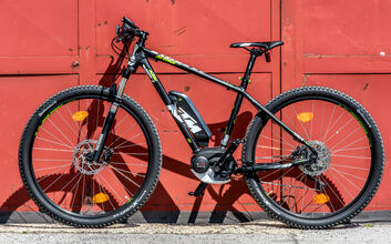 Fahrradvergleich_HEN5129_CMS.jpg E-Bike der Marke KTM steht vor rotem Tor.