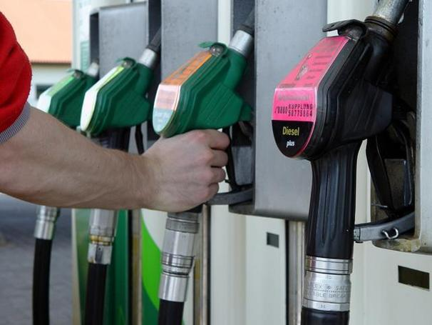 Tankstelle.jpg Zapfsäule mit vier Zapfpistolen. Eine Hand greift zu einer Zapfpistole